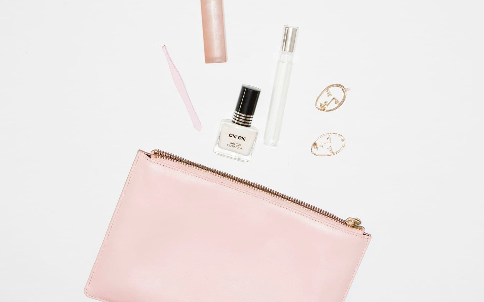 A small canvas makeup bag with nine products laid out beside it